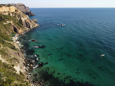 海景空中全景与水晶般清澈的蔚蓝大海和岩石海岸 在岩石背景下的美丽泻湖中的游艇 夏季旅行和度假的理想目的地的概念帆船蓝色石头休息日背景图片