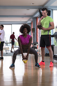 在交叉体操场与个人教练一起锻炼闲暇肌肉夫妻运动女士成人运动员女性权重俱乐部背景图片