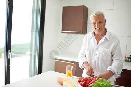 男人在家做饭 在厨房准备沙拉白色情绪微笑水平照片蔬菜成人厨师料理衣服背景图片