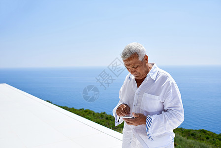 使用智能电话的高级男子手机老年人头发自拍微笑细胞快乐男人海洋技术背景图片