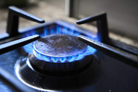 炊具作为加热器 自然资源的浪费 燃气灶的蓝色火焰产生温室气体排放 燃烧器上的厨房炉排以可燃天然气或合成气 丙烷 丁烷为燃料背景