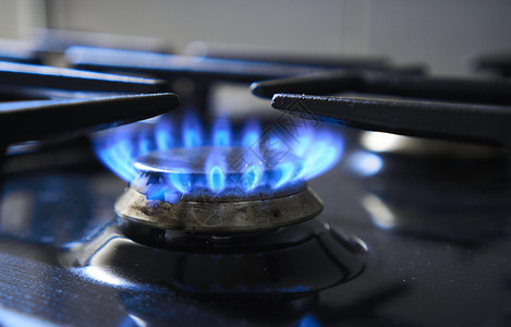 燃烧器上的厨房炉排以可燃天然气或合成气 丙烷 丁烷为燃料 炊具作为加热器 自然资源的浪费 燃气灶的蓝色火焰产生温室气体排放背景