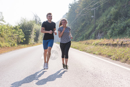 农村男人在乡村公路上慢跑的年轻夫妇森林男性女孩训练活动跑步运动员阳光运动装男人背景