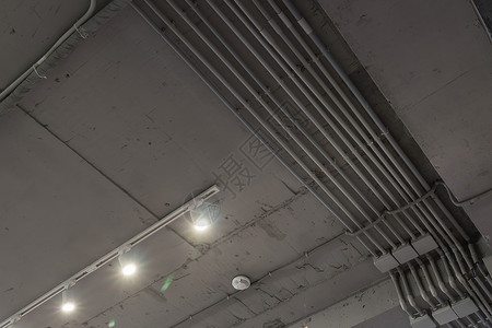 带通风和安全摄像头的混凝土灰色天花板抽象阁楼内部 用现代灯具装饰的工业阁楼的室内建筑和天花板设计仓库办公室公寓商业工厂框架建筑学背景图片