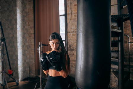 在体育馆打拳击的年轻女子冲孔竞赛女性运动绷带锻炼斗争力量拳击手运动员背景图片