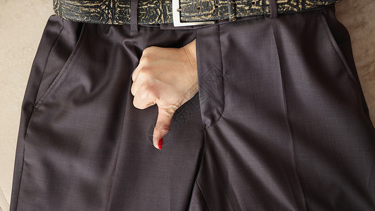 女人用男人裤把拇指伸下手表情手势运动裤裤子桌子手指带子阳痿女性按钮腰带背景图片