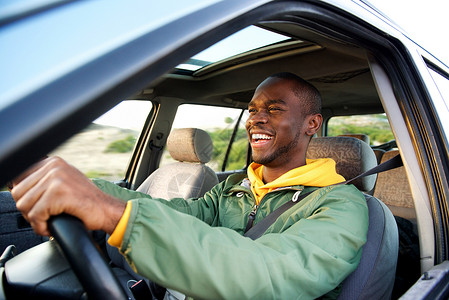 快乐的非洲美国人驾驶汽车的一面高清图片