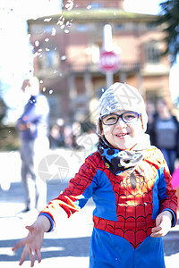 超级英雄蜘蛛侠带着红蜘蛛超级英雄装扮的漂亮孩子 在玩彩蛋面具超级英雄天空游戏幸福乐趣纸屑戏服力量想像力背景