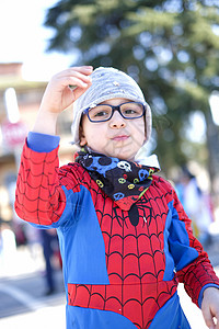 超级英雄蜘蛛侠带着红蜘蛛超级英雄装扮的漂亮孩子 在玩彩蛋童年乐趣男生男性想像力喜悦超级英雄面具英雄蓝色背景