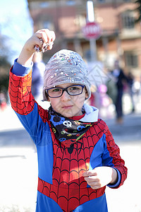 超级英雄蜘蛛侠带着红蜘蛛超级英雄装扮的漂亮孩子 在玩彩蛋超级英雄力量童年游戏戏服纸屑男生五彩面具飞行背景