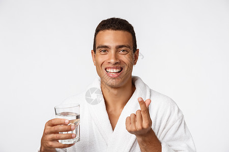 一个有魅力的男人 在白色背景下 喝杯水的好男人男性运动爆炸健康幸福成人玻璃微笑快乐手指背景图片