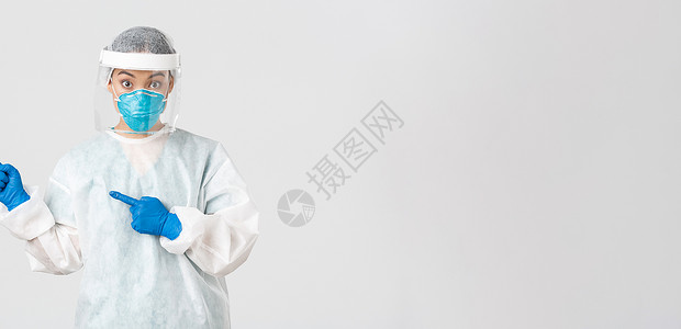 Covid19 冠状病毒病 医护人员的概念 惊讶的亚洲女医生 医用呼吸器医生和指向左上角的个人防护设备面罩诊所女性临床社交学生药背景图片