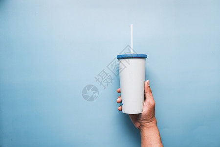 持有可重复使用的生态咖啡杯 蓝色和复制空间背景图片