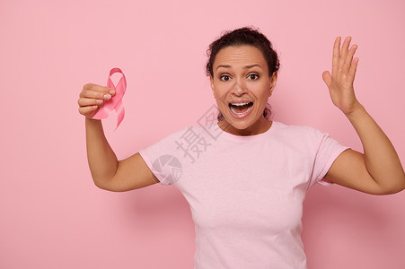10月的乳癌意识月 与粉丝丝带一起穿粉红色T恤的妇女 以支持人们生活和疾病 (注 Pink Ripbon为 白丝带 )背景