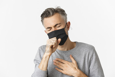 戴黑色口罩covid19 的概念 社会距离和检疫 站在白色背景下 戴着黑色医用面具 咳嗽 感觉不舒服的中年男子特写社交情感快乐商业广告男性背景