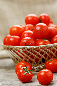 樱桃篮子小红番茄 在旧木制桌边的篮子上 里普和多汁樱桃乡村桌子饮食柳条收成水果叶子食谱蔬菜木头背景