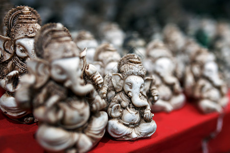 Ganesh的石雕像是绿色的 与印度市场对面的光块Ganesh形成对比手工精神手工业纪念品旅游雕像工艺店铺旅行收藏背景图片