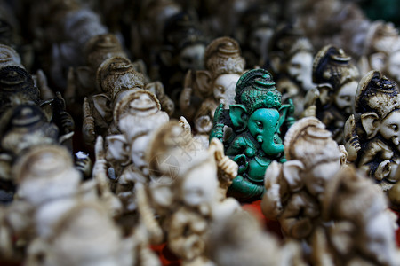 Ganesh的石雕像是绿色的 与印度市场对面的光块Ganesh形成对比手工寺庙工艺手工业旅游雕塑雕像收藏游客崇拜背景图片