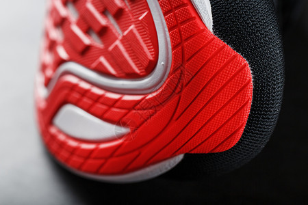 红色跑步运动鞋底板的缝合 红色跑棒球衣服城市生活竞赛阳光培训师锻炼女性活力皮革背景图片