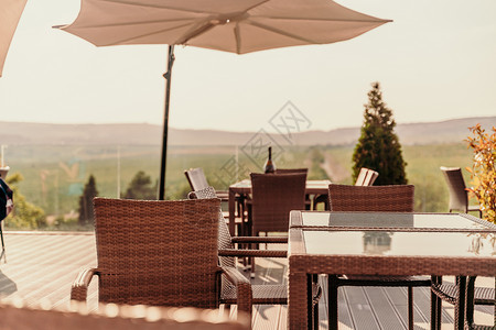 街道咖啡厅的空桌子 俯瞰着山和树木 太阳雨伞假期游客建筑椅子旅行餐厅城市旅游石头街道背景图片