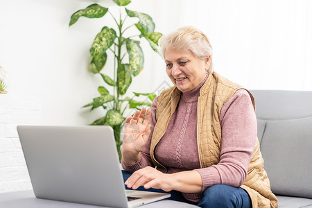 在家里或办公室工作的严肃成熟的老年妇女在笔记本电脑上观看培训网络研讨会 60 多岁的中年女商务人士在使用计算机技术时做笔记用户程背景图片