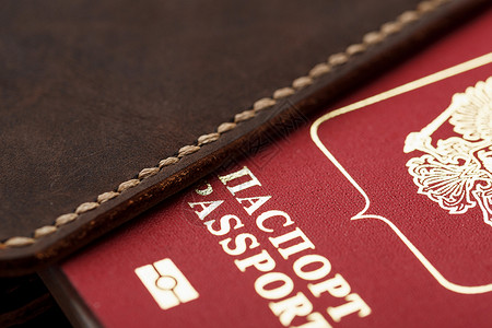 黑色背景带红色护照的棕色皮革封面部门旅行游客安全身份海关文档假期卡片移民背景图片