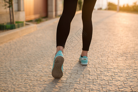妇女健身日出慢跑锻炼健康概念 在公路上紧贴鞋子的路上跑步活力耐力身体闲暇活动娱乐训练运动员慢跑女孩背景图片