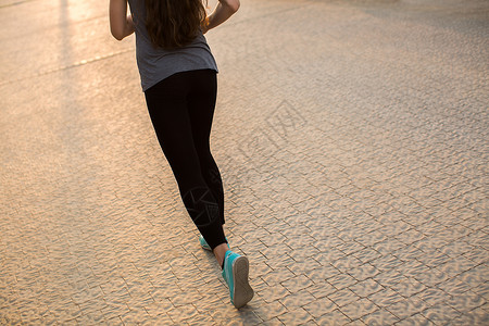 妇女健身日出慢跑锻炼健康概念 在公路上紧贴鞋子的路上跑步训练日落运动运动员成人耐力街道娱乐慢跑城市背景图片
