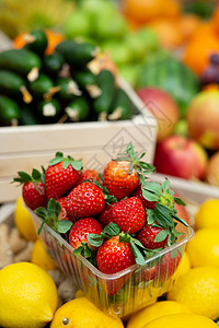 蔬菜水果蔬菜店柜台上的草莓托盘异国情调店铺营养柠檬橙子季节果汁篮子黄瓜背景