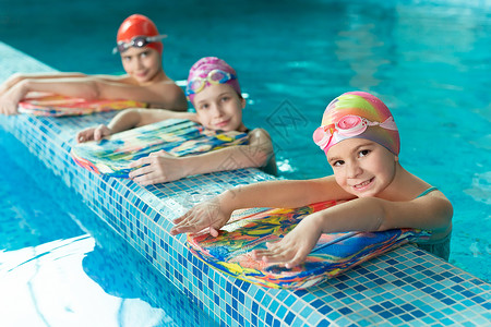 在游泳池中的儿童 在培训期间有游泳板背景图片