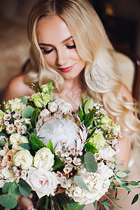 漂亮的新娘拿着婚礼花束 闭着眼睛装扮金发卷曲女性女孩化妆品花朵白色身材长发冒充背景图片