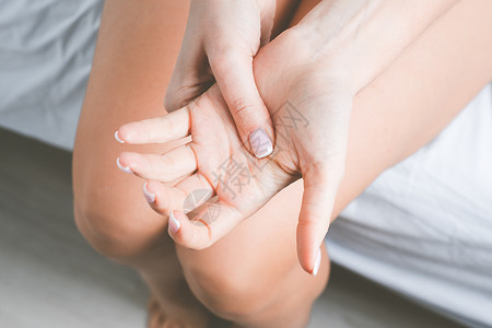 患有手痛或手指痛的妇女 睡后手麻或四肢麻木 按摩痛苦的手背景图片