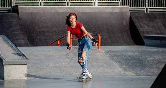 滚筒速度滑冰户外有滚冰鞋的女孩公园轮滑闲暇行动滚筒晴天速度女性溜冰者运动背景
