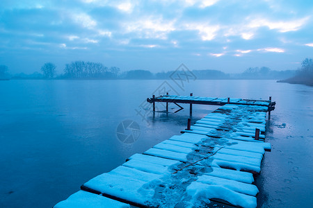 被雪覆盖码头冰冻和薄雾湖的码头背景