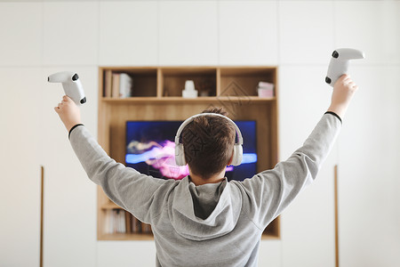 电子游戏宣传男孩在耳机上观看电视 少年男孩在家里屏幕前玩电子游戏 (笑声)背景