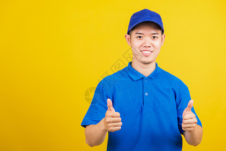 举小红旗导游身穿蓝色T恤衫和帽子制服微笑 手举大拇拇指的手势经销商男性衬衫商业职业员工工作室手指相机运输背景