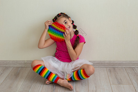 彩虹裙一个快乐的黑发女孩 拿着彩虹 把它放在她的手中背景