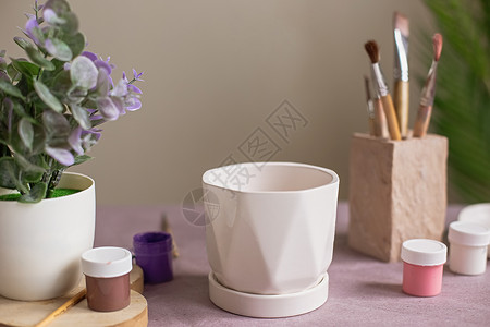 白陶瓷花盆的死活 站在紫色克拉夫纸上的桌子上背景