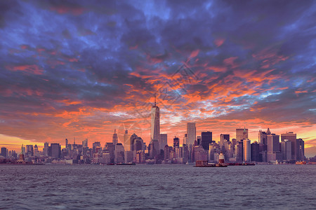 纽约市曼哈顿市中心黄昏时段的天际线上 有摩天大楼在哈德逊河全景处照亮城市建筑场景全景市中心码头帝国反射日落天空背景