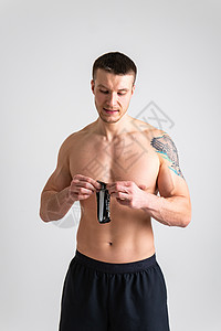 男人在白色背景下吃蛋白质棒 与世隔绝的年轻饮食健康 饮食适合运动的生活方式 美味的糖分吸引女性背景图片
