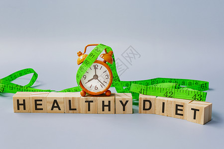 八点以测量水龙头和橙色时钟制成的木板块立方体上的健康饮食文字背景