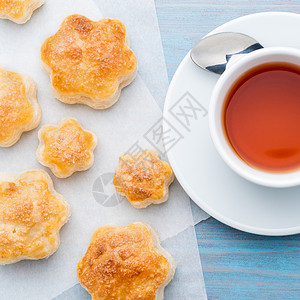 康普茶传统早餐 包括一杯茶和甜糕点 — 烤饼 一杯茶 勺子 在木制蓝色桌子上 俯视背景