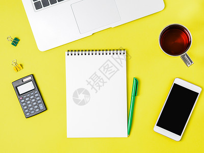 文图文字素材现代有创意的黄色办公桌 配有膝上型电脑 智能手机和其他配件 中视图顶端文字为空白笔记本页面背景