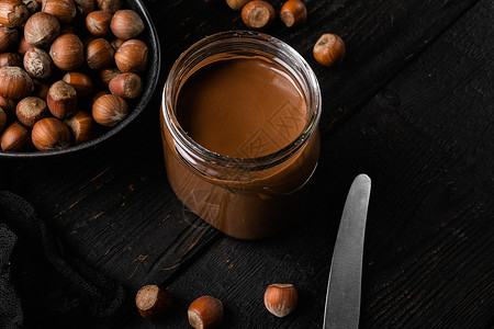 木制的榛子巧克力撒布或甜甜奶油加栗子 黑木桌背景背景