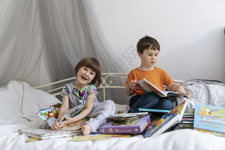 两个兄弟姐妹在沙发上读书图书小学生姐姐哥哥女孩长沙发时刻游戏知识分子情感背景图片