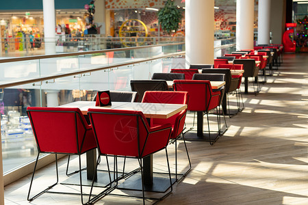 一排椅子一间现代购物中心食品法院的参观者可坐一排桌椅和软椅子背景