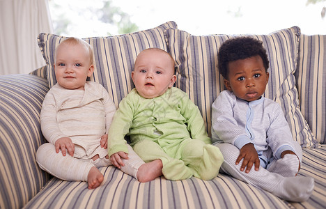 前三个月从小就交朋友 三个可爱的婴儿坐在沙发上的肖像背景