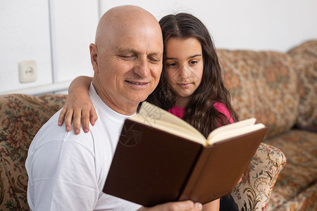 快乐的祖父和孙女在家里一起看书 快关门吧背景图片