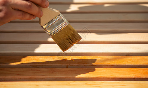 涂漆木制家具和清漆 一个人把一棵树藏着清漆硬木栅栏工具木材工艺木头背景木工木匠家具背景图片