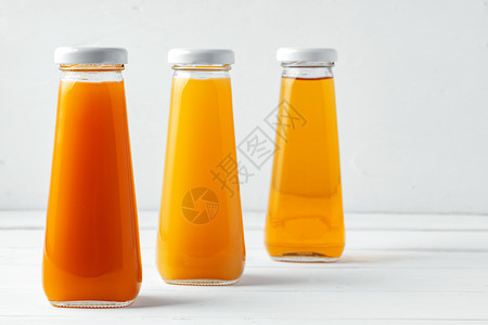 白色背景上不同果汁的玻璃杯瓶液体产品瓶子婴儿水果饮料玻璃蔬菜饮食橙子背景图片